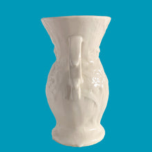 Load image into Gallery viewer, Beautiful vintage Bird of Paradise vase glazed in gloss white, features embossed bird and botanicals. Crafted by McCoy Pottery, 1940s. This vase is must for any art pottery collector!

In vintage condition, no repairs, chip on the foot. There is crazing present and one of the lines penetrates both sides at the rim, and appears stable. Maker&#39;s mark on the bottom.

Measures 4 7/8 x 3 3/4 x 8 inches
