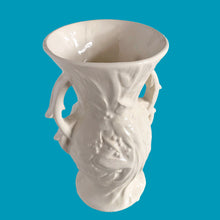 Load image into Gallery viewer, Beautiful vintage Bird of Paradise vase glazed in gloss white, features embossed bird and botanicals. Crafted by McCoy Pottery, 1940s. This vase is must for any art pottery collector!

In vintage condition, no repairs, chip on the foot. There is crazing present and one of the lines penetrates both sides at the rim, and appears stable. Maker&#39;s mark on the bottom.

Measures 4 7/8 x 3 3/4 x 8 inches
