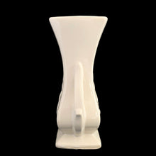 Load image into Gallery viewer, Beautiful vintage gloss white handled vase, features embossed fern. Crafted by McCoy Pottery, late 1940s. This vase is must for any art pottery collector!

In excellent vintage condition, minor spot of roughness to the rim along with age-related crazing. Maker&#39;s mark on the bottom.

Measures 5 1/2 x 3 5/8 x 8 1/8 inches
