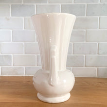 Load image into Gallery viewer, Vintage Art Deco gloss white handled trumpet vase with embossed flowers. Crafted by McCoy Pottery, 1950s. This rare piece is must for any McCoy art pottery collector!

In excellent vintage condition, no chips/cracks/repairs. Maker&#39;s mark.

Measures 4 1/4 x 8 1/8 inches
