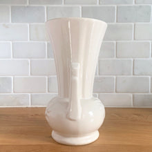 Load image into Gallery viewer, Vintage Art Deco gloss white handled trumpet vase with embossed flowers. Crafted by McCoy Pottery, 1950s. This rare piece is must for any McCoy art pottery collector!

In excellent vintage condition, no chips/cracks/repairs. Maker&#39;s mark.

Measures 4 1/4 x 8 1/8 inches
