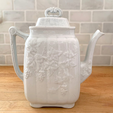 Rare antique white ironstone coffee pot embossed with grapevines on both sides. Crafted by W. & E. CORN, Burslem, England, 1864-1891. A fine example of early English earthenware. It's absolutely stunning and would make a wonderful addition to any ironstone collection!

In excellent condition, no chips/cracks/repairs. Maker's stamped mark present.

Measures 8 1/2 x 4 7/8 x 8 7/8 inches (incl. handle/spout)