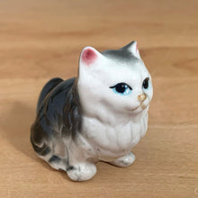 Load image into Gallery viewer, Delightful vintage gray and white cat porcelain figurine. Japan. Add this sweet figurine to your collection!

In excellent condition, no chips/cracks.

Measures 2 x 7/8 x 1 3/4 inches
