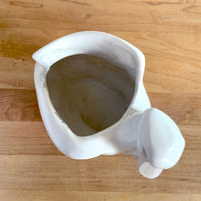 Load image into Gallery viewer, Vintage mid-century era matte white Pelican pattern planter. Crafted by Nelson McCoy Pottery, 1948. Perfect as a succulent planter or to hold baby accessories as part of your nursery decor! This rare piece is must for any art pottery collector.

In excellent vintage condition, no chips/cracks/repairs, age-related crazing and interior staining. Manufacturer's glaze pops. Maker's mark.

Measures 7 3/4 x 4 1/4 x 5 1/2 inches
