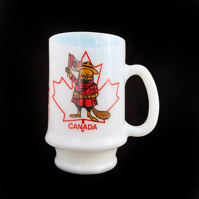 A vintage white opalescent mug imprinted with an adorable beaver dressed as Canadian Mounted Police uniform, waving the canadian flg superimposed over a graphic maple leaf illustration with CANADA underneath.  In excellent condition, free from chips/wear.  Measures 2 3/4 x 4 5/8 inches
