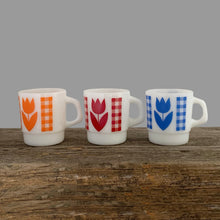 Load image into Gallery viewer, Vintage milk glass mug with vibrant tulip flowers and gingham check bands. Choose from red, orange or blue. Crafted by Termoscrisa Glass, Mexico. Circa 1980s. Perfect for your cuppa Joe!  In excellent condition, no chips/wear.  Measures 3 x 3 3/8 inches  Capacity 8 ounces
