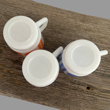 Load image into Gallery viewer, Vintage milk glass mug with vibrant tulip flowers and gingham check bands. Choose from red, orange or blue. Crafted by Termoscrisa Glass, Mexico. Circa 1980s. Perfect for your cuppa Joe!  In excellent condition, no chips/wear.  Measures 3 x 3 3/8 inches  Capacity 8 ounces
