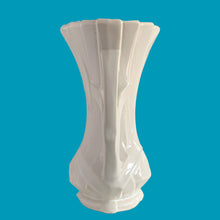 Load image into Gallery viewer, Vintage shiny white glazed ribbon strap vase with double handles. Crafted by McCoy Pottery, 1940s. A must for any art pottery collector!

In excellent condition, no chips, no cracks, no repairs and no visible crazing which is incredible for a piece of this age. Maker&#39;s mark on the bottom.

Measures 7 3/4 x 12 inches

