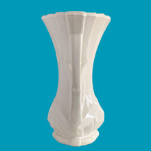 Load image into Gallery viewer, Vintage shiny white glazed ribbon strap vase with double handles. Crafted by McCoy Pottery, 1940s. A must for any art pottery collector!

In excellent condition, no chips, no cracks, no repairs and no visible crazing which is incredible for a piece of this age. Maker&#39;s mark on the bottom.

Measures 7 3/4 x 12 inches
