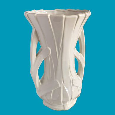 Vintage shiny white glazed ribbon strap vase with double handles. Crafted by McCoy Pottery, 1940s. A must for any art pottery collector!

In excellent condition, no chips, no cracks, no repairs and no visible crazing which is incredible for a piece of this age. Maker's mark on the bottom.

Measures 7 3/4 x 12 inches