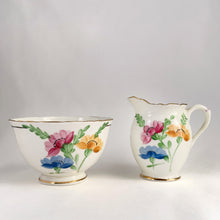Load image into Gallery viewer, Vintage bone china wild flowers creamer and sugar, featuring hand painted florals in shades of pink, blue, yellow and green with gold gilt trim and scalloped edges. Crafted by Delphine China, England, 1920s. A lovely way to enhance your tea and coffee experience!

In excellent condition, no chips, cracks or repairs. Maker&#39;s mark on the bottom.

Creamer measures 1 7/8 x 2 3/4 inches | Sugar measures 3 5/8 x 2 1/4 inches
