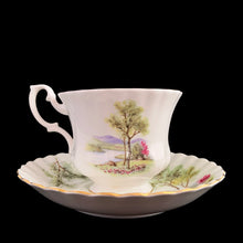 Load image into Gallery viewer, This vintage bone china footed teacup and saucer is so sweet! Both the cup and saucer are decorated with a woodland country scene with pink flowers. Each piece has a lovely scalloped shape, trimmed with gold gilt. Produced by Richmond, England, 1950s-70s.

In excellent condition, no chips, cracks or repairs. Maker&#39;s mark on the bottom.

Teacup measures 3 1/2 x 2 3/4 inches | Saucer measures 5 1/2 inches
