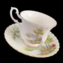 Load image into Gallery viewer, This vintage bone china footed teacup and saucer is so sweet! Both the cup and saucer are decorated with a woodland country scene with pink flowers. Each piece has a lovely scalloped shape, trimmed with gold gilt. Produced by Richmond, England, 1950s-70s.

In excellent condition, no chips, cracks or repairs. Maker&#39;s mark on the bottom.

Teacup measures 3 1/2 x 2 3/4 inches | Saucer measures 5 1/2 inches
