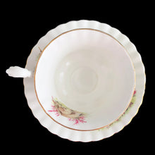Load image into Gallery viewer, This vintage bone china footed teacup and saucer is so sweet! Both the cup and saucer are decorated with a woodland country scene with pink flowers. Each piece has a lovely scalloped shape, trimmed with gold gilt. Produced by Richmond, England, 1950s-70s.

In excellent condition, no chips, cracks or repairs. Maker&#39;s mark on the bottom.

Teacup measures 3 1/2 x 2 3/4 inches | Saucer measures 5 1/2 inches
