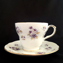 Load image into Gallery viewer, Vintage Woodside white bone china teacup and saucer features purple violets, trimmed in gold gilt. Crafted by Duchess, England, 1960s. A lovely way to enjoy a cuppa tea!

In excellent condition, no chips, cracks or repairs. Maker&#39;s mark on the bottom.

Measures 3 7/8 x 2 3/4 x 5 1/2 inches
