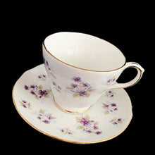 Load image into Gallery viewer, Vintage Woodside white bone china teacup and saucer features purple violets, trimmed in gold gilt. Crafted by Duchess, England, 1960s. A lovely way to enjoy a cuppa tea!

In excellent condition, no chips, cracks or repairs. Maker&#39;s mark on the bottom.

Measures 3 7/8 x 2 3/4 x 5 1/2 inches
