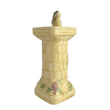 Load image into Gallery viewer, Beautifully detailed, vintage Art Deco Flaxman Ware matte yellow glazed castle tower pitcher featuring a budgie bird atop the handle, along with purple and green florals. Crafted by Wade, Heath &amp; Co., England, 1930s. This decorative and highly collectible piece makes a lovely decor accent.

In good vintage condition with chip on the bottom of the foot, typical crazing. Maker&#39;s mark on the bottom.

Measures 5 x 4 x 7 3/4 inches

