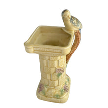 Load image into Gallery viewer, Beautifully detailed, vintage Art Deco Flaxman Ware matte yellow glazed castle tower pitcher featuring a budgie bird atop the handle, along with purple and green florals. Crafted by Wade, Heath &amp; Co., England, 1930s. This decorative and highly collectible piece makes a lovely decor accent.

In good vintage condition with chip on the bottom of the foot, typical crazing. Maker&#39;s mark on the bottom.

Measures 5 x 4 x 7 3/4 inches
