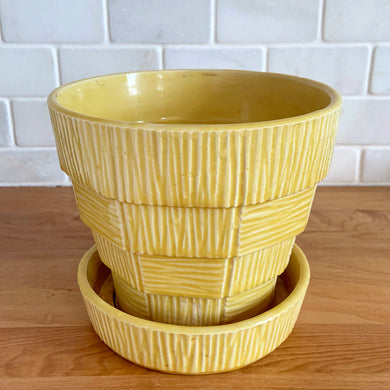 Highly collectible vintage mid-century yellow basketweave ceramic art pottery planter with attached underplate. Crafted by McCoy Pottery, USA, 1950s. The perfect home for your favourite houseplant or succulent!

In excellent vintage condition, no chips/cracks/repairs, age-related crazing. Maker's mark.

Measures 6 1/2 x 5 5/8 inches