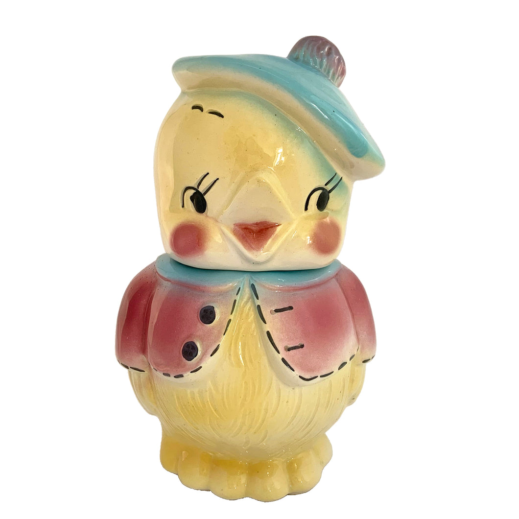 Vintage mid-century hand painted figural chick ceramic cookie jar, hand painted in shades of yellow, wearing a pink and blue jacket with black stitching and topped with a blue and pink beret. Crafted by American Bisque, USA, circa 1950s. Add some kitsch to your kitchen decor with this adorable collectible!

In excellent condition, minor chip on the underside of the foot, no cracks, age-related crazing.

Measures 6 x 7 x 11 3/4 inches