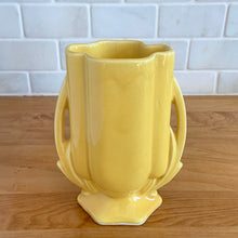 Load image into Gallery viewer, Vintage Art Deco yellow vase features a unique shape and double leaf decorative handles, 105. Crafted by McCoy Pottery, 1940s. This rare piece is must for any art pottery collector! A lovely way to enhance your home&#39;s decor or give as a gift!

In excellent vintage condition, no chips/cracks/repairs. Typical age-related crazing, manufacturer&#39;s glaze pops. Unmarked.

Measures 4 x 2 1/8 x 5 1/2 inches
