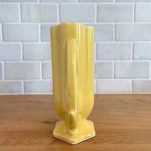 Load image into Gallery viewer, Vintage Art Deco yellow vase features a unique shape and double leaf decorative handles, 105. Crafted by McCoy Pottery, 1940s. This rare piece is must for any art pottery collector! A lovely way to enhance your home&#39;s decor or give as a gift!

In excellent vintage condition, no chips/cracks/repairs. Typical age-related crazing, manufacturer&#39;s glaze pops. Unmarked.

Measures 4 x 2 1/8 x 5 1/2 inches
