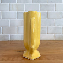 Load image into Gallery viewer, Vintage Art Deco yellow vase features a unique shape and double leaf decorative handles, 105. Crafted by McCoy Pottery, 1940s. This rare piece is must for any art pottery collector! A lovely way to enhance your home&#39;s decor or give as a gift!

In excellent vintage condition, no chips/cracks/repairs. Typical age-related crazing, manufacturer&#39;s glaze pops. Unmarked.

Measures 4 x 2 1/8 x 5 1/2 inches
