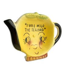 Load image into Gallery viewer, Adorable vintage mid-century hand painted figural ceramic yellow teapot teabag holder dish featuring the inscription &quot;I will hold the teabag&quot; atop a smiling face. The teabag holder can be displayed vertically when not in use as part of your kitsch kitchen decor....so cute!  In excellent condition, no chips/cracks/repairs. Marked &quot;Japan&quot;.  Measures 4 1/4 x 3 inches
