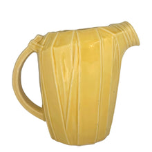 Load image into Gallery viewer, Exceptional vintage gloss yellow art deco leaf wrapped pitcher with strap handle. Crafted by McCoy Pottery, 1949. This rare pitcher must for any art pottery collector!

In excellent vintage condition, no chips/crack/repairs, no noticeable crazing. Maker&#39;s mark on the bottom.

Measures 8 x 5 x 7 3/4 inches (incl. handle)

Capacity 55 ounces
