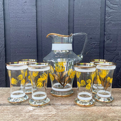 Vintage blown glass lemonade pitcher and glasses set hand painted with yellow flowers with gold leaves, white and gold bands and rims. Crafted in Romania, 1950s. A lovely set to add cheer to your table.

In excellent condition, no chips. Original stickers marked, Made in Roumania.

Pitcher measures 8 1/2 x 11 inches. Capacity 80 ounces

Glasses measure 3 1/2 x 5 7/8 inches. Capacity 16 ounces