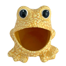 Load image into Gallery viewer, Elevated front view of Vintage yellow lava glaze ceramic frog sponge holder, showing the large open hollow mouth, two bulging black eyes, and webbed front feet flat on the base
