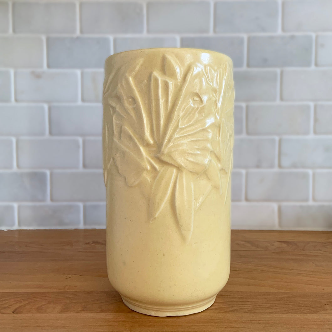 Vintage Art Deco matte yellow Butterfly Line cylinder vase. Crafted by Nelson McCoy Pottery, early 1940s. This rare piece is must for any art pottery collector! A lovely way to enhance your home's decor or give as a gift!

In good vintage condition, no chips/cracks/repairs. Heavy age-related crazing, manufacturer's glaze pops. Maker's marks.

Measures 4 3/8 x 8 1/8 inches