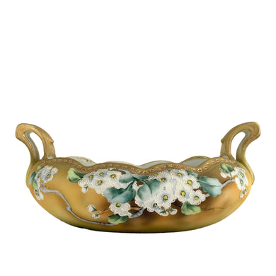 A lovely vintage Nippon oval handled bowl, hand painted in matte yellow, green and ochre featuring clusters of white flowers outlined in white moriage with green leaves. The bowl is finished with a scalloped edge, decorated with detailed gold moriage and gilt. Crafted by artisans in Japan, circa 1920s. A stunning piece!