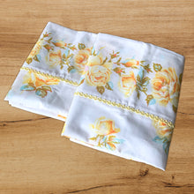 Load image into Gallery viewer, Dress your bed with this lovely pair of vintage Truprest &quot;Rose Romance&quot; polyester/cotton white pillowcases featuring roses in shades of yellow with pale blue and green leaves. Each pillowcase is finished with a patterned band with yellow trim detail. Manufactured by Texmade, Canada, circa 1970s. Create a restful slumber with these beautifully designed and well-made linens!  In excellent condition, free from tears/stains. New old stock.  Measures 33 1/2 x 20 1/2 inches   
