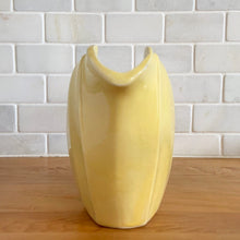 Load image into Gallery viewer, Charming vintage sunny yellow tulip pitcher. Crafted by McCoy Pottery, 1940s. This collectible pitcher is the perfect vessels to hold a charming bouquet of spring flowers or a lovely gift for an art pottery collector.

In as found vintage condition, chip to the rim and handle, tight horizontal hairline crack on handle, age-related crazing, manufacturer&#39;s glaze pops. Maker&#39;s mark.

Measures 8 1/4 x 3 1/2 x 6 inches
