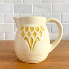 Load image into Gallery viewer, Antique vintage art deco ceramic creamer pitcher 1504 featuring an impressed yellow window or thistle on pale yellow ground. Crafted by Robinson Ransbottom Pottery Co., USA, 1920s. A unique piece to add to your art pottery tableware collection!

In excellent condition, no chips/cracks/repairs, normal age-related crazing. Maker&#39;s marks.

Measures 4 1/2 x 3 1/4 x 4 1/4 inches

