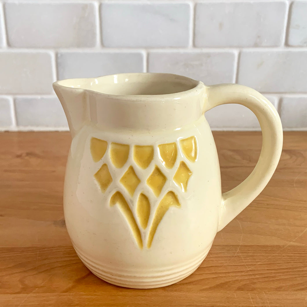 Antique vintage art deco ceramic creamer pitcher 1504 featuring an impressed yellow window or thistle on pale yellow ground. Crafted by Robinson Ransbottom Pottery Co., USA, 1920s. A unique piece to add to your art pottery tableware collection!

In excellent condition, no chips/cracks/repairs, normal age-related crazing. Maker's marks.

Measures 4 1/2 x 3 1/4 x 4 1/4 inches