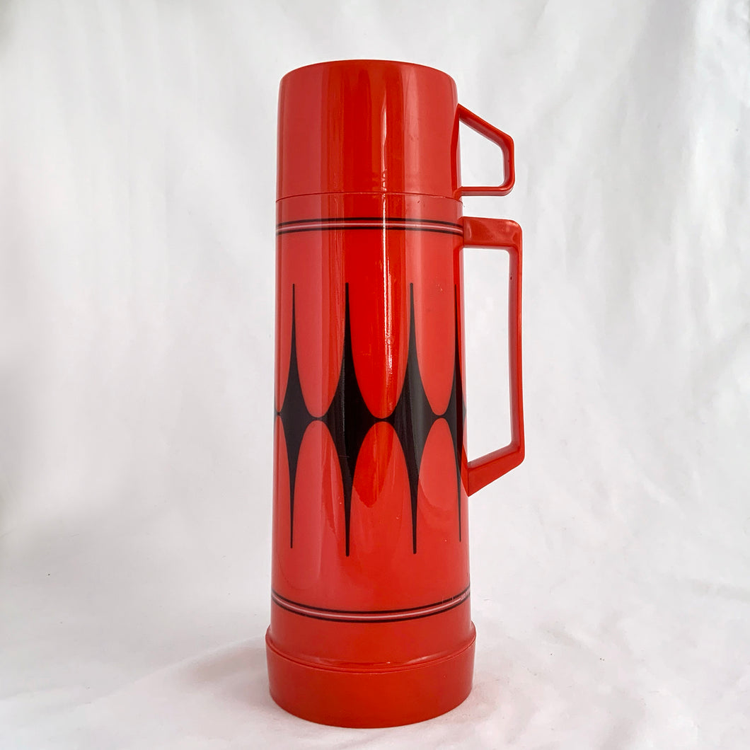 This Aladdin thermos is fire engine red with a harlequin pattern of black diamonds accompanies by black and white bands on either side. Perfect for those early morning at the rink or the ice hut. Easily fits into a backpack.   In excellent condition, barely looks used. Made in Canada.  No 223 Cup | No 30 Stopper | No 012C Filler |455ml capacity  Measures 3 1/2 x 10 1/8 inches