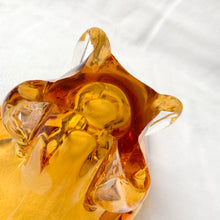 Load image into Gallery viewer, A stunning piece of amber art glass ashtray. Makes a beautiful addition to home decor. Use as trinket dish, catchall, candy dish or as originally intended. Made by Lorraine Glass, Canada, circa 1970.   In good vintage condition. A few minor flea bites at the base which are barely noticeable. The bottom is polished smooth.  Measures 6 3/4 x 4 x 4 inches
