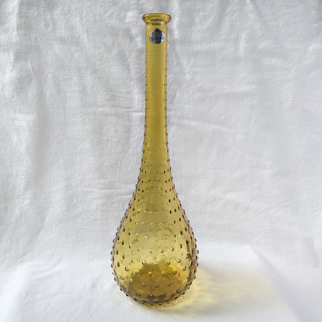 A fabulous amber art glass hobnail patterned genie bottle produced by glass artisans of Guildcraft in the Empoli region of Italy. This superb mid-century piece of art glass would make a unique addition to your home decor collection. Perfect as a decanter, vase or decor piece. Dates between 1950 to 1970. These bottles are incredibly beautiful and highly collectible.  In excellent vintage condition, no chips or cracks. Original sticker.  Measures 6 x 16 inches