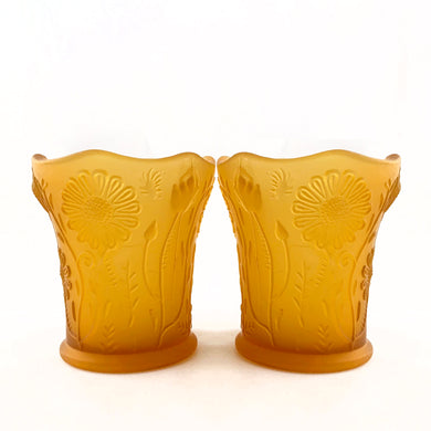 Pair of vintage amber satin glass candle votive holders with an embossed pattern of daisy flowers with a scalloped edge. Made in Taiwan, circa 1980.  In excellent condition, free from chips/cracks.  Measures 2-1/8