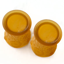 Load image into Gallery viewer, Pair of vintage amber satin glass candle votive holders with an embossed pattern of daisy flowers with a scalloped edge. Made in Taiwan, circa 1980.  In excellent condition, free from chips/cracks.  Measures 2-1/8&quot; x 3&quot;
