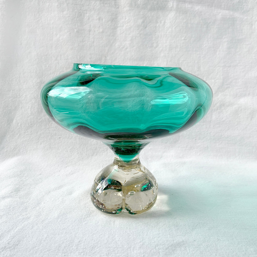 Gorgeous vintage mid-century art glass pedestal bowl in a beautiful shade of teal and the glass has a wave which catches the light. The base is clear and clover shaped, with lovely controlled bubbles. Designed by Bo Bergstöm for Aseda Glass of Sweden.  In excellent condition, no cracks. There is the tiniest flea nick on the inside rim of the bowl which is literally invisible.   Measures 6 x 2 1/2 inches