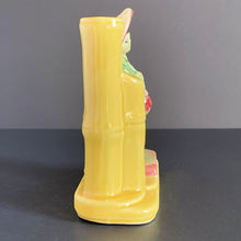 Load image into Gallery viewer, Sweet decorative yellow vase with an Asian figure on a podium standing beside a bamboo stalk which acts as the vase. Shape 702, produced by Shawnee Pottery USA. Perfect as a bud vase or your favourite mini plant or succulent.  In good vintage condition, no cracks. Small glaze loss spot to front of the yellow foot, see photos.  Measures 5 x 2 1/2 x 5 1/2 inches
