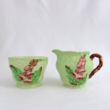 Load image into Gallery viewer, Vintage light green porcelain creamer and sugar decorated in the &quot;Australian Design&quot;  of pink foxgloves with impressed leaf patterns. Produced by Carlton Ware, England, circa 1930s.  Both pieces are in excellent  condition, free from chips/cracks/repairs.  Stamped maker&#39;s marks Carlton Ware MADE IN ENGLAND &quot;TRADE MARK&quot; REGISTRATION APPLIED FOR.  Creamer measures 2 3/4 x 2 5/8 inches and the sugar measures 3 1/8 x 2 1/8 inches

