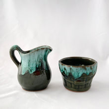 Load image into Gallery viewer, A vintage green drip glaze creamer and open sugar bowl set. The sugar bowl is in the shape of a old fashioned bucket...super cool! The contrast of the colours is outstanding. Produced by McMaster Canada, circa 1970.  Excellent condition, no chips or cracks.  Creamer measures 4 1/4 x 4 1/4 inches  Sugar measures 3 1/2 x 2 1/2 inches
