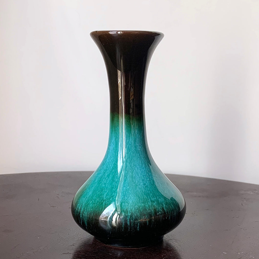 The pride of Collingwood, Ontario, Blue Mountain Pottery! This lovely bud vase will compliment and floral bouquet. Typical with BMP pottery, it has a drip glaze finish in deep greens and black.   Excellent condition, no chips or cracks.  Size: 3.25