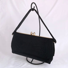 Load image into Gallery viewer, 1940s art deco vintage black Corde embroidered evening bag with gold toned kiss closure. The interior is lined with black fabric having both a long brass zippered compartment and an open pocket in front of it. This bag is spacious enough to carry a full-sized cell phone, credit cards, cash, compact, lipstick, tissues. Produced by Gold Seal in the USA. Excellent vintage condition. Faded Gold Seal printed mark present on the interior. Some pin holes on the interior.
