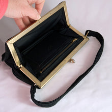 Load image into Gallery viewer, 1940s art deco vintage black Corde embroidered evening bag with gold toned kiss closure. The interior is lined with black fabric having both a long brass zippered compartment and an open pocket in front of it. This bag is spacious enough to carry a full-sized cell phone, credit cards, cash, compact, lipstick, tissues. Produced by Gold Seal in the USA. Excellent vintage condition. Faded Gold Seal printed mark present on the interior. Some pin holes on the interior.

