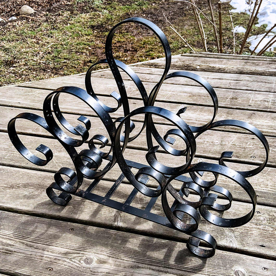 This fabulous vintage mid-century record stand or magazine/newspaper rack has all the curves with its circular rounded scroll design! Leave as found or can be spray painted as desired to match your decor. Perfect to display your vinyl or magazine collection!  In great vintage condition, all welds intact with some discolouration/colour loss in spots as seen in the photos (zoom in to see details).   Measures 19 x 6 x 15 3/4 inches